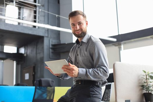 Young businessman using his tablet in the office