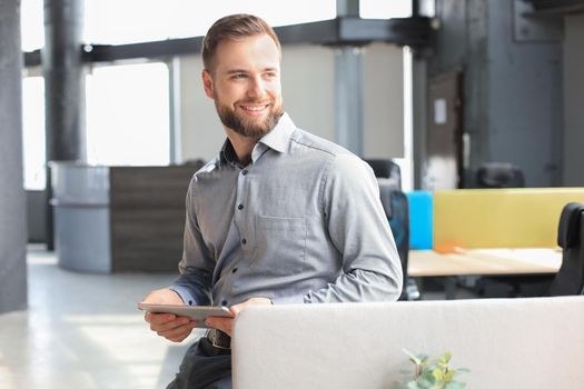 Young businessman using his tablet in the office