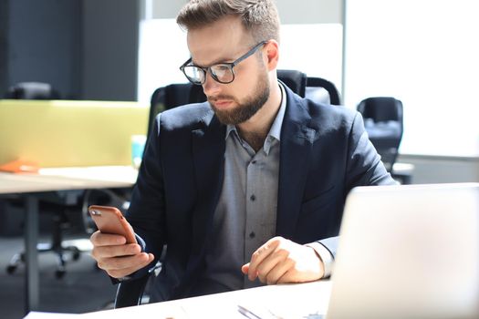 Businessman using his mobile phone in the office