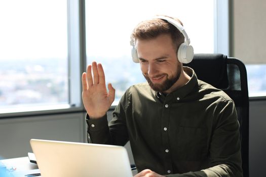 Smiling young business man having video call in office