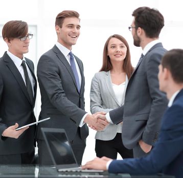 handshake business partners after signing a contract.