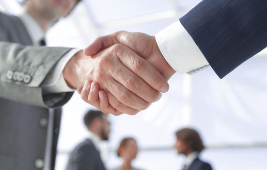 closeup.reliable handshake of business partners on the background of business team