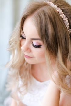 Portrait of pretty bride and bridal makeup with diadem. Concept of black eyelashes and tender make up.