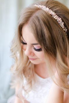 Portrait of beautiful bride and bridal makeup with diadem. Concept of black eyelashes and tender make up.