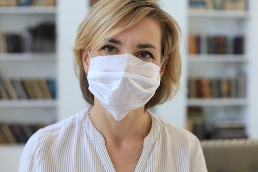 Middle aged woman in medical mask at home during epidemic situation