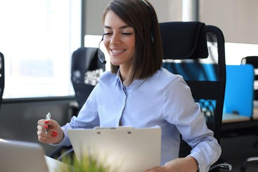 Female customer support operator with headset and smiling
