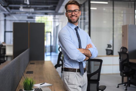 Young handsome businessman smiling in an office environment