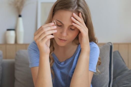 Sad woman sitting on a sofa in the living room