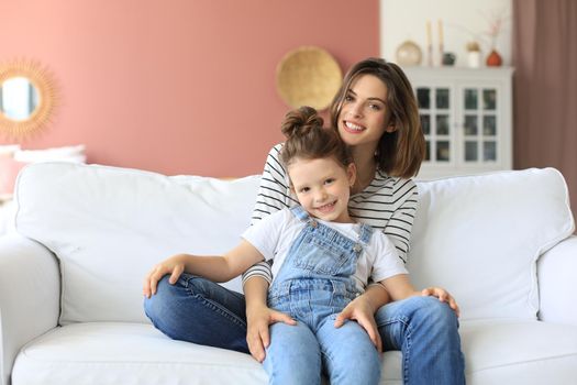 Happy loving mom hugging little daughter, spend time together at home