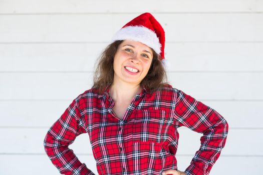 people, christmas and clothing concept - young woman in santa costume posing on white background.