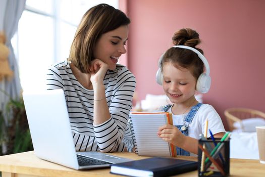 Mother and little daughter doing homework online. Distance learning online education