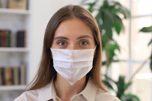 Young woman in medical mask at home during epidemic situation