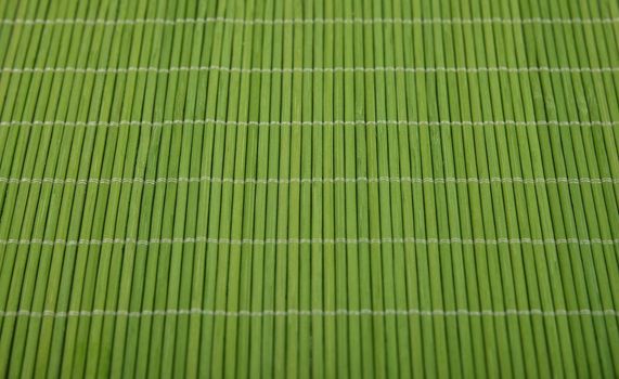 Close up natural green bamboo wood mat background texture, high angle view, personal perspective