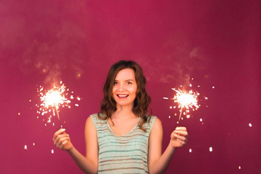 Woman holding sparklers. Christmas, new year and holidays concept.