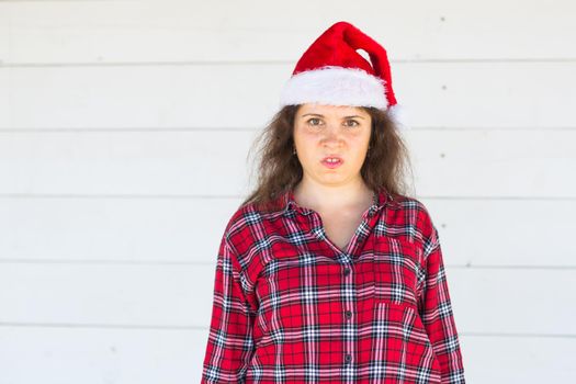 Christmas, people, emotions concept - dissatisfied angry santa in christmas hat .