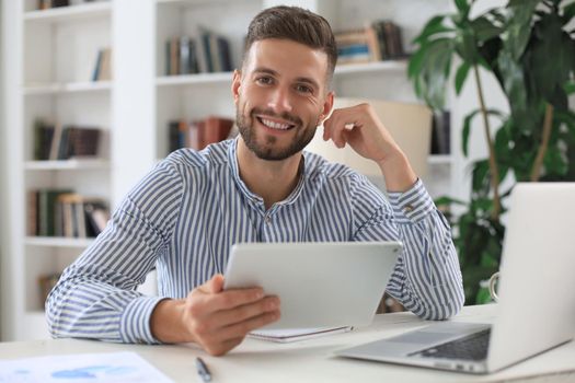 Happy young business man is analizing financial documents from home during self isolation
