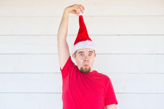 Holidays, christmas and clothing concept - surprised funny man in santa costume posing on white background.