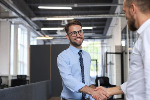 Two business colleagues shaking hands during meeting