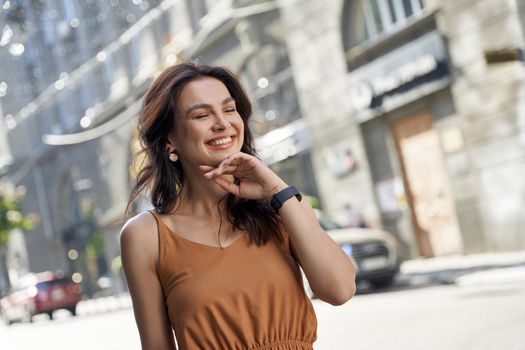 Happy people. Portrait of a young attractive woman keeping eyes closed and smiling while walking on the city streets on a summer sunny day. Outdoors portrait. positive emotions