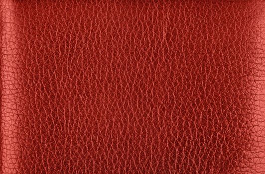 Close up background texture pattern of maroon red natural leather grain, directly above