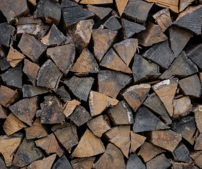 Close up stack of dry firewood oak wooden logs, chopped, split and organized in a pile for winter fuel stock, low angle, side view