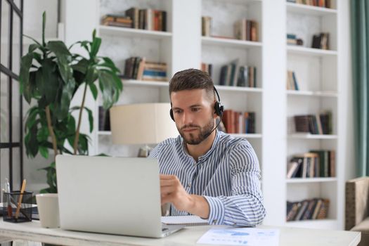 Thoughtful modern business man working using laptop while sitting in the office