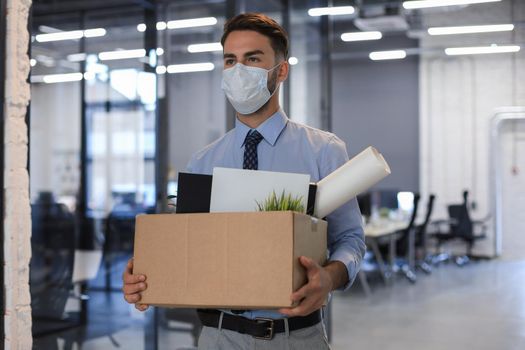 Dismissal employee in an epidemic coronavirus. Dismissed worker going from the office with his office supplies