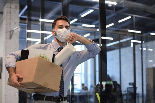 Dismissal employee in an epidemic coronavirus. Dismissed worker going from the office with his office supplies