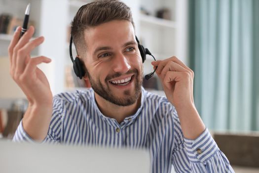Smiling young business man having video call in office