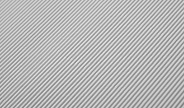 Close up diagonal background pattern texture of white corrugated packaging cardboard