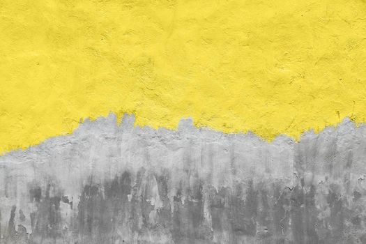 Old yellow painted gray plaster concrete wall with weatherstains, runs and defects