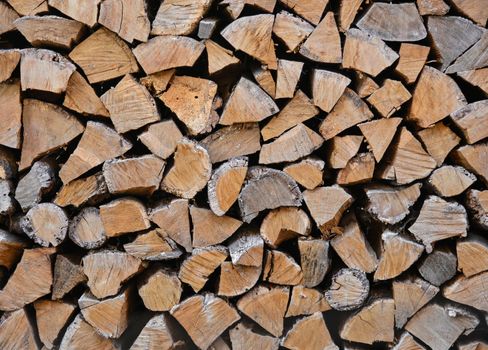 Close up stack of dry firewood oak wooden logs, chopped, split and organized in a pile for winter fuel stock, low angle, side view