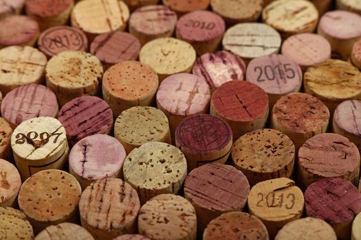 Close up background pattern of many assorted stacked used red wine corks, high angle view