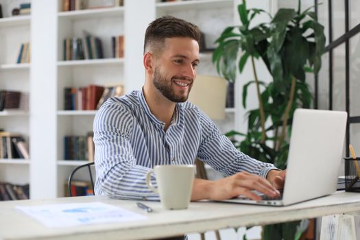 Happy young business man is analizing financial documents from home during self isolation