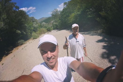 senior dad and son taking selfie photos on  hiking tour