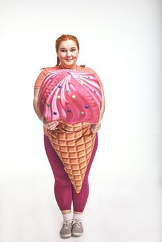 Funny picture of amusing, red haired, chubby woman on white background. Woman is holding a huge ice cream