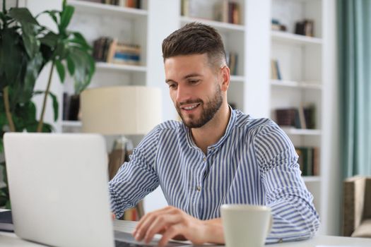 Happy young business man is analizing financial documents from home during self isolation