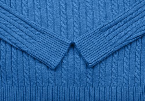 Close up background texture of blue cable knitted wool jersey fabric sweater with row braid pattern