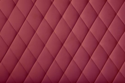 Background texture of burgundy purple soft tufted furniture or wall panel upholstery with deep diamond pattern, close up