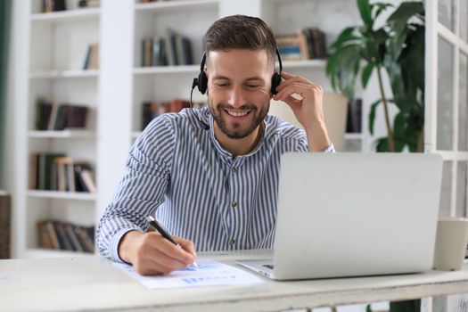 Thoughtful modern business man working using laptop while sitting in the office