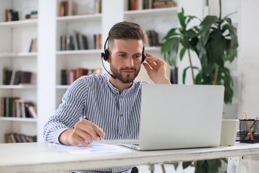 Thoughtful modern business man working using laptop while sitting in the office