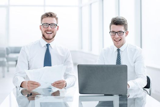 smiling colleagues sitting at the Desk. photo with copy space