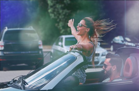 happy young woman enjoying a ride in a convertible car.city life
