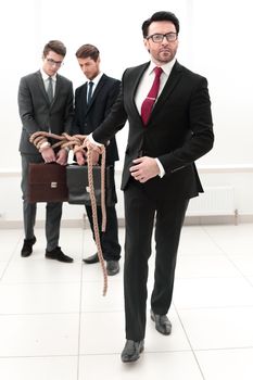 confident businessman pulls the rope tied employees.business concept