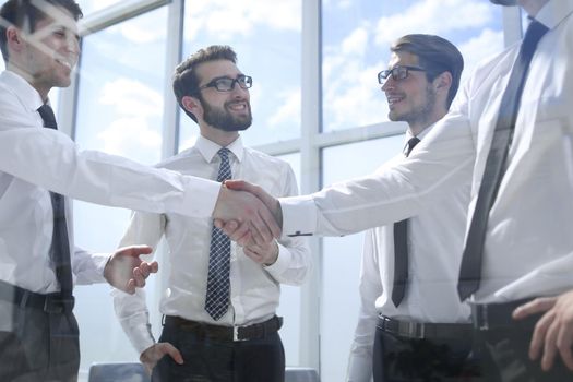 successful employees shaking hands at the workplace in the office.business concept