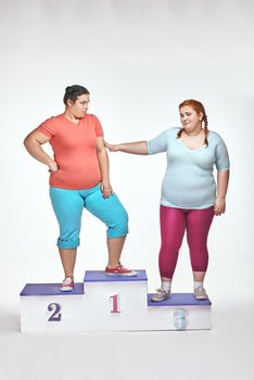 Overweight women are standing on a winner's pedestal isolated on white background and argue