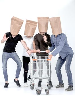 men with paper bags on head and shopping cart in hands on isolated background