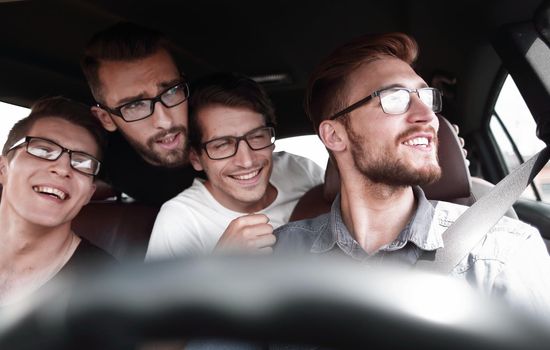 Portrait of a group of friends sitting in a new car