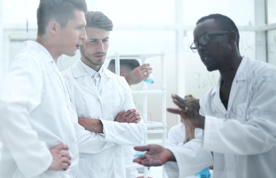 Group of scientists in food laboratory with samples in petri dishes