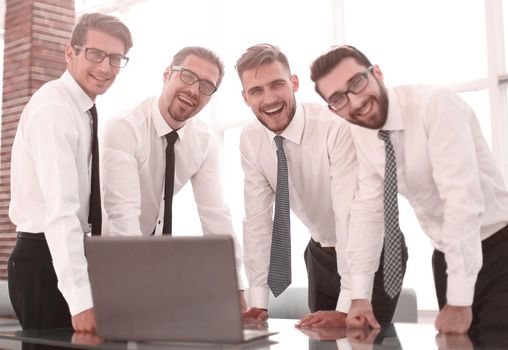 close up.smiling group of employees standing near the office Desk.the concept of teamwork